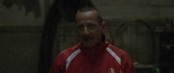 Movie still from “Bullhead” (2011), directed by Michaël R. Roskam – A person wearing a red jacket; Close Up shot, Over the shoulder angle