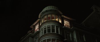 Movie still from “Bullhead” (2011), directed by Michaël R. Roskam – A very tall building at night lit up by the lights; Extreme Wide shot, Low angle