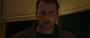 Movie still from “Bullhead” (2011), directed by Michaël R. Roskam – A person wearing a black shirt; Close Up shot, Over the shoulder angle