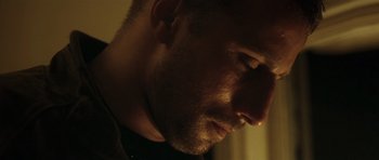 Movie still from “Bullhead” (2011), directed by Michaël R. Roskam – A man's face in the dark; Close Up shot, Low angle