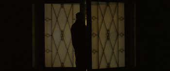 Movie still from “Bullhead” (2011), directed by Michaël R. Roskam – A person standing in front of a window; Wide shot, Low angle