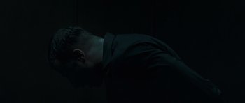 Movie still from “Bullhead” (2011), directed by Michaël R. Roskam – A man with his head down in a dark room; Close Up shot, Low angle
