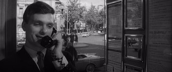Movie still from “Bunny Lake Is Missing” (1965), directed by Otto Preminger – A man talking on a phone next to a busy street; Close Up shot, Low angle