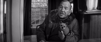 Movie still from “Bunny Lake Is Missing” (1965), directed by Otto Preminger – An older man holding a small dog in his lap; Close Up shot, Over the shoulder angle