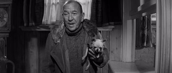 Movie still from “Bunny Lake Is Missing” (1965), directed by Otto Preminger – An older man holding a small dog in his arms; Close Up shot, High angle