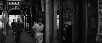 Movie still from “Bunny Lake Is Missing” (1965), directed by Otto Preminger – A woman standing in front of a store looking in the window; Medium shot, Low angle