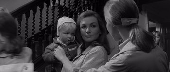 Movie still from “Bunny Lake Is Missing” (1965), directed by Otto Preminger – A woman holding a baby in her arms and another woman standing next to her; Close Up shot, Over the shoulder angle