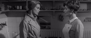 Movie still from “Bunny Lake Is Missing” (1965), directed by Otto Preminger – A woman in a trench coat and a man in a white shirt; Medium shot, Over the shoulder angle