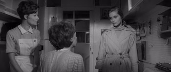 Movie still from “Bunny Lake Is Missing” (1965), directed by Otto Preminger – A woman in a trench coat is looking at a boy in a striped shirt; Medium shot, Over the shoulder angle
