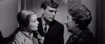 Movie still from “Bunny Lake Is Missing” (1965), directed by Otto Preminger – Two women and a man in a suit and tie; Close Up shot, Over the shoulder angle