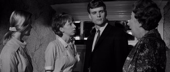 Movie still from “Bunny Lake Is Missing” (1965), directed by Otto Preminger – A man and a woman standing next to each other; Close Up shot, Low angle