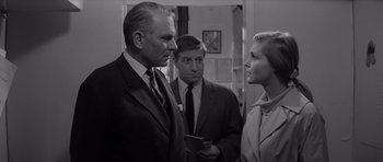 Movie still from “Bunny Lake Is Missing” (1965), directed by Otto Preminger – Two men and a woman in a black and white photo; Medium shot, Over the shoulder angle