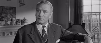 Movie still from “Bunny Lake Is Missing” (1965), directed by Otto Preminger – An older man wearing a suit and tie; Close Up shot, Low angle