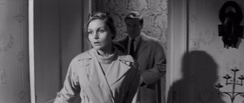 Movie still from “Bunny Lake Is Missing” (1965), directed by Otto Preminger – A man and a woman standing next to each other in a room; Medium shot, Over the shoulder angle