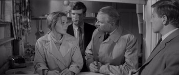 Movie still from “Bunny Lake Is Missing” (1965), directed by Otto Preminger – A man and two women are talking to each other in a kitchen; Medium shot, Over the shoulder angle