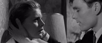 Movie still from “Bunny Lake Is Missing” (1965), directed by Otto Preminger – A woman sitting in front of a lamp looking sad; Close Up shot, Over the shoulder angle