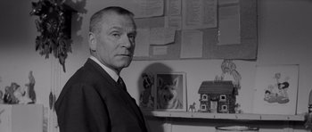 Movie still from “Bunny Lake Is Missing” (1965), directed by Otto Preminger – Black and white photograph of a man in a suit and tie; Close Up shot, Low angle