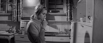 Movie still from “Bunny Lake Is Missing” (1965), directed by Otto Preminger – A woman is standing in a kitchen by a sink; Medium shot, High angle
