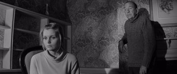 Movie still from “Bunny Lake Is Missing” (1965), directed by Otto Preminger – A woman standing next to a man in front of a wall; Medium shot, Low angle