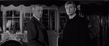 Movie still from “Bunny Lake Is Missing” (1965), directed by Otto Preminger – A black and white photo of two men standing next to each other; Close Up shot, Low angle