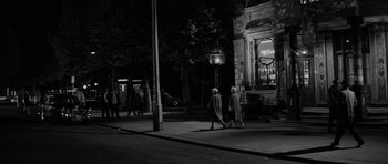Movie still from “Bunny Lake Is Missing” (1965), directed by Otto Preminger – A couple of people walking down a street at night; Wide shot, High angle
