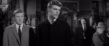 Movie still from “Bunny Lake Is Missing” (1965), directed by Otto Preminger – A man in a black coat and a tie; Close Up shot, Over the shoulder angle