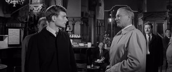 Movie still from “Bunny Lake Is Missing” (1965), directed by Otto Preminger – Two men in a room talking to each other; Medium shot, Over the shoulder angle