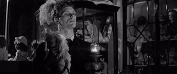 Movie still from “Bunny Lake Is Missing” (1965), directed by Otto Preminger – A black and white photo of a man holding a candle; Close Up shot, Low angle