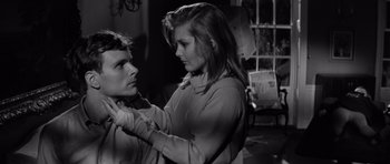 Movie still from “Bunny Lake Is Missing” (1965), directed by Otto Preminger – A young woman is putting lipstick on a young man's face; Close Up shot, Low angle