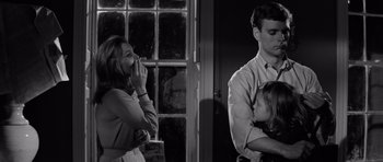 Movie still from “Bunny Lake Is Missing” (1965), directed by Otto Preminger – A man and a woman standing next to a little girl; Medium shot, Over the shoulder angle