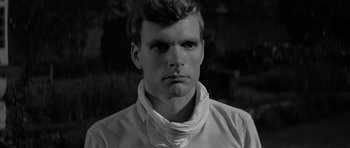 Movie still from “Bunny Lake Is Missing” (1965), directed by Otto Preminger – Black and white photograph of a man with a scarf around his neck; Close Up shot, High angle