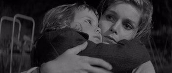 Movie still from “Bunny Lake Is Missing” (1965), directed by Otto Preminger – A woman holding a young child in her arms; Close Up shot, Over the shoulder angle