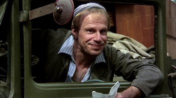 Movie still from “Burnt by the Sun” (1994), directed by Nikita Mikhalkov – A man wearing a kippah is smiling for the camera; Medium shot, Low angle