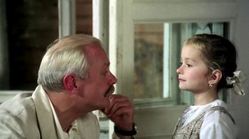 Movie still from “Burnt by the Sun” (1994), directed by Nikita Mikhalkov – An older man and a young girl looking at each other; Close Up shot, Over the shoulder angle