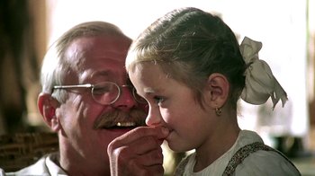 Movie still from “Burnt by the Sun” (1994), directed by Nikita Mikhalkov – An older man and a young girl looking at each other; Close Up shot, Over the shoulder angle