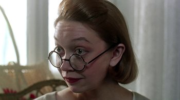 Movie still from “Burnt by the Sun” (1994), directed by Nikita Mikhalkov – A woman wearing glasses and a white shirt; Close Up shot, Low angle