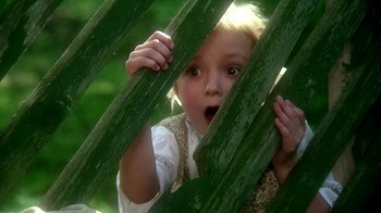 Movie still from “Burnt by the Sun” (1994), directed by Nikita Mikhalkov – A little girl peeking through a wooden fence; Close Up shot, High angle