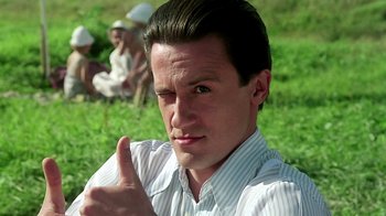 Movie still from “Burnt by the Sun” (1994), directed by Nikita Mikhalkov – A man giving a thumbs up in front of a group of people; Close Up shot, Low angle