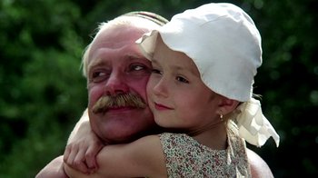 Movie still from “Burnt by the Sun” (1994), directed by Nikita Mikhalkov – An older man and a young girl are hugging; Close Up shot, Low angle