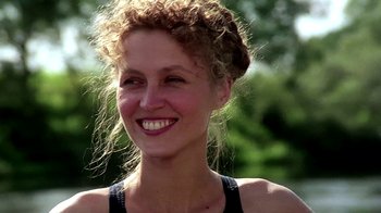 Movie still from “Burnt by the Sun” (1994), directed by Nikita Mikhalkov – A person smiling with trees in the background; Close Up shot, Over the shoulder angle