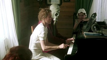 Movie still from “Burnt by the Sun” (1994), directed by Nikita Mikhalkov – A woman sitting in front of a piano; Medium shot, Over the shoulder angle
