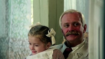 Movie still from “Burnt by the Sun” (1994), directed by Nikita Mikhalkov – An older man and a young girl are posing for a picture; Close Up shot, Low angle