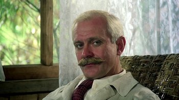 Movie still from “Burnt by the Sun” (1994), directed by Nikita Mikhalkov – An older man with a mustache sitting in a chair; Close Up shot, Low angle