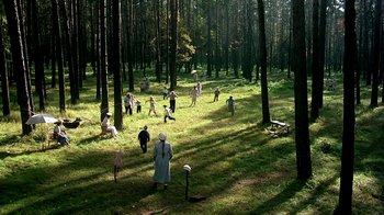 Movie still from “Burnt by the Sun” (1994), directed by Nikita Mikhalkov – A group of people standing in the middle of a forest; Extreme Wide shot, High angle