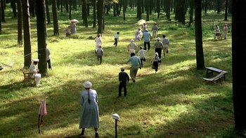 Movie still from “Burnt by the Sun” (1994), directed by Nikita Mikhalkov – A group of people walking through a field; Extreme Wide shot, High angle