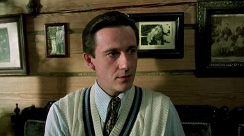 Movie still from “Burnt by the Sun” (1994), directed by Nikita Mikhalkov – A young man wearing a sweater and a tie; Close Up shot, Low angle