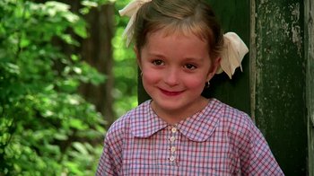 Movie still from “Burnt by the Sun” (1994), directed by Nikita Mikhalkov – A little girl wearing a plaid shirt and white bows in her hair; Close Up shot, Low angle