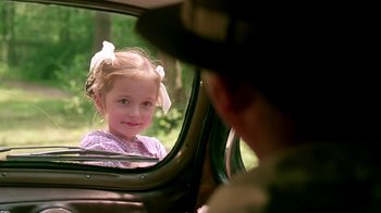 Movie still from “Burnt by the Sun” (1994), directed by Nikita Mikhalkov – A little girl sitting in the back seat of a car; Close Up shot, Over the shoulder angle