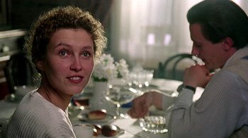 Movie still from “Burnt by the Sun” (1994), directed by Nikita Mikhalkov – A woman sitting at a table with a man; Close Up shot, Over the shoulder angle