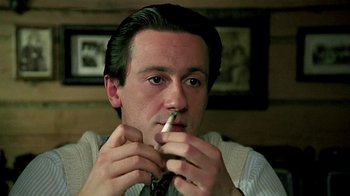 Movie still from “Burnt by the Sun” (1994), directed by Nikita Mikhalkov – A man is smoking a cigarette while wearing a tie; Close Up shot, High angle